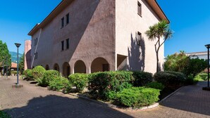 A building with a distinct architectural style, featuring a prominent corner tower and a series of arches along the facade. - La Plage d'Ir ène (Appartement n°36) - Avec balcon (San-Nicolao)