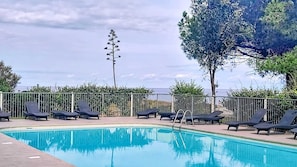 A swimming pool with lounge chairs and a view of the sea. - La Plage d'Irène (Appartement n°36) - Avec balcon (San-Nicolao)