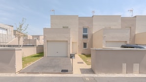 Ein modernes Wohngebäude mit Garage, einer kleinen Auffahrt und blauem Himmel.