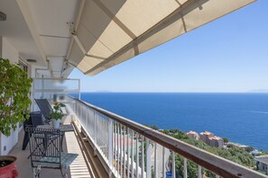 A balcony with a view of the sea, a potted plant, and a metal chair. - Le Nid de Bastia - Bel appt avec balcon et vue mer (Ville-di-Pietrabugno)