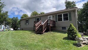 A single-story house with a front deck and a small staircase leading to the entrance. - 3-bedroom campground in delightful Covington with AC comfort (Covington)