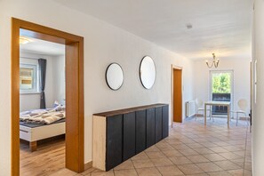 A modern bedroom with a bed, a bedside table, and a large mirror on the wall. - Apartment 'Ferienhaus Am Wasserfall 1.Unit' with Mountain View, Private Terrace and Wi-Fi (Oberried)