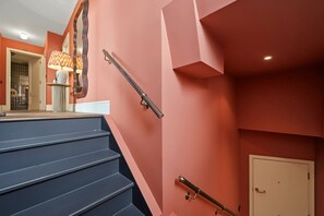 A staircase with handrails, a door, and a mirror reflecting a lamp. - Skyline terraces & double-height living near Borough Market (London)