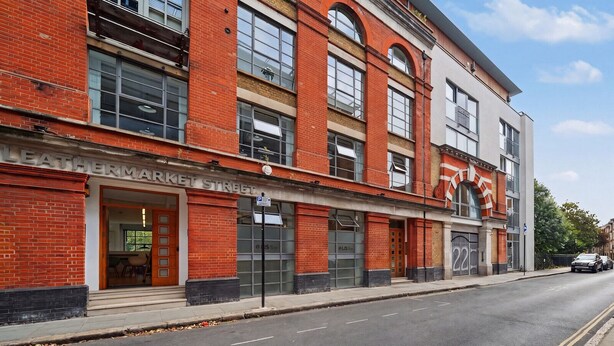Un edificio a più piani con un negozio al piano terra chiamato 'LEATHERMARKET STREET'.