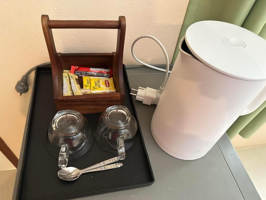 Una bandeja con dos vasos, una cuchara y una caja de pañuelos.