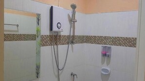 A bathroom with a shower, toilet, and a towel rack.