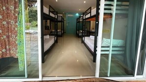A corridor with bunk beds, a glass door, and a view of the outdoors.