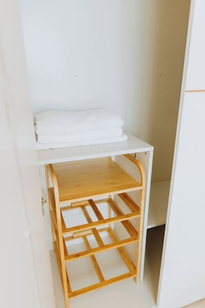 Ein weißer Schrank mit einer Holzablage und einem unteren Fach mit einem Holzgestell.