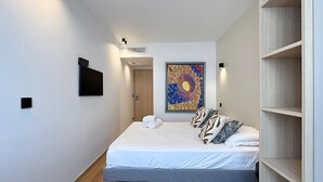 Ein Schlafzimmer mit einem Bett, einem Bild, einem Kleiderschrank und einer Tür.
