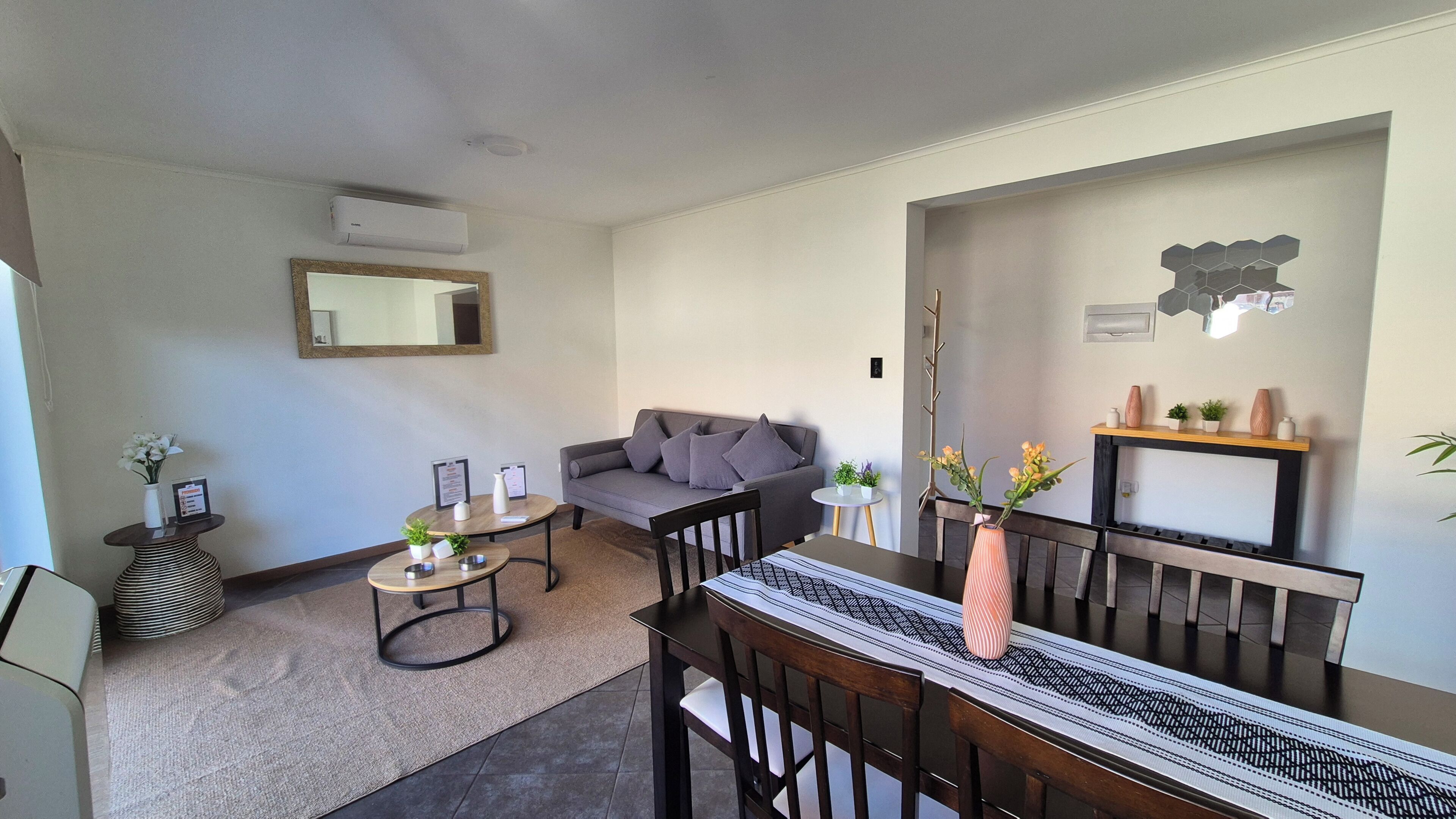 Un salon moderne comprenant un canapé, une table à manger avec des chaises, une table basse et une cheminée.