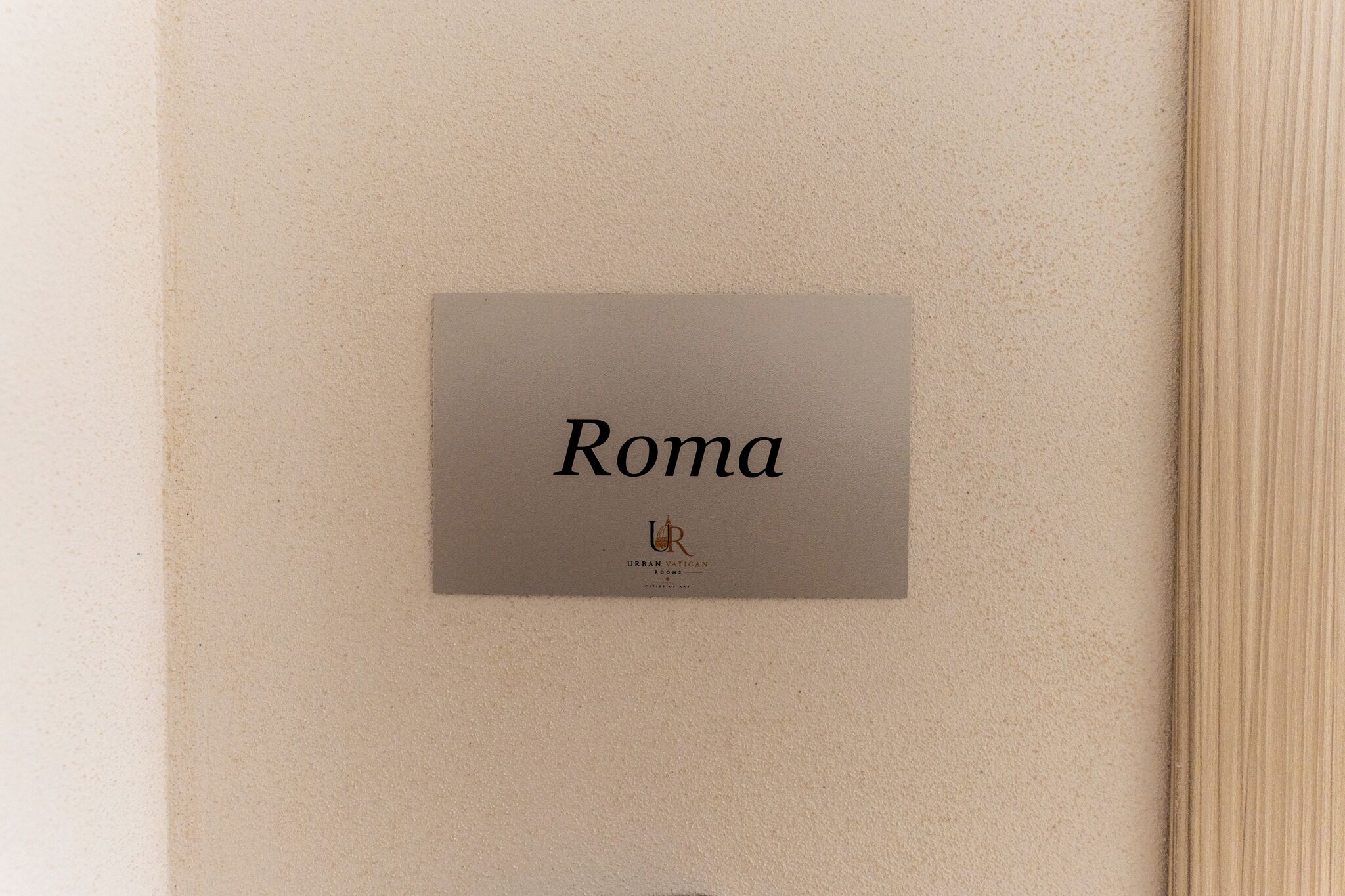 A book or brochure with the title 'Roma' and the logo 'URBAN VATICAN ROMS CITIES OF ART' on a textured beige background.