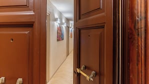 A hallway with wooden doors and a brass handle. - Urban Vatican Rooms Cities of Art (Roma)