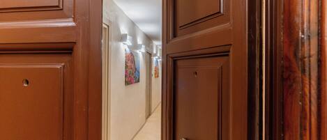 Un pasillo con puertas de madera y un picaporte de latón.