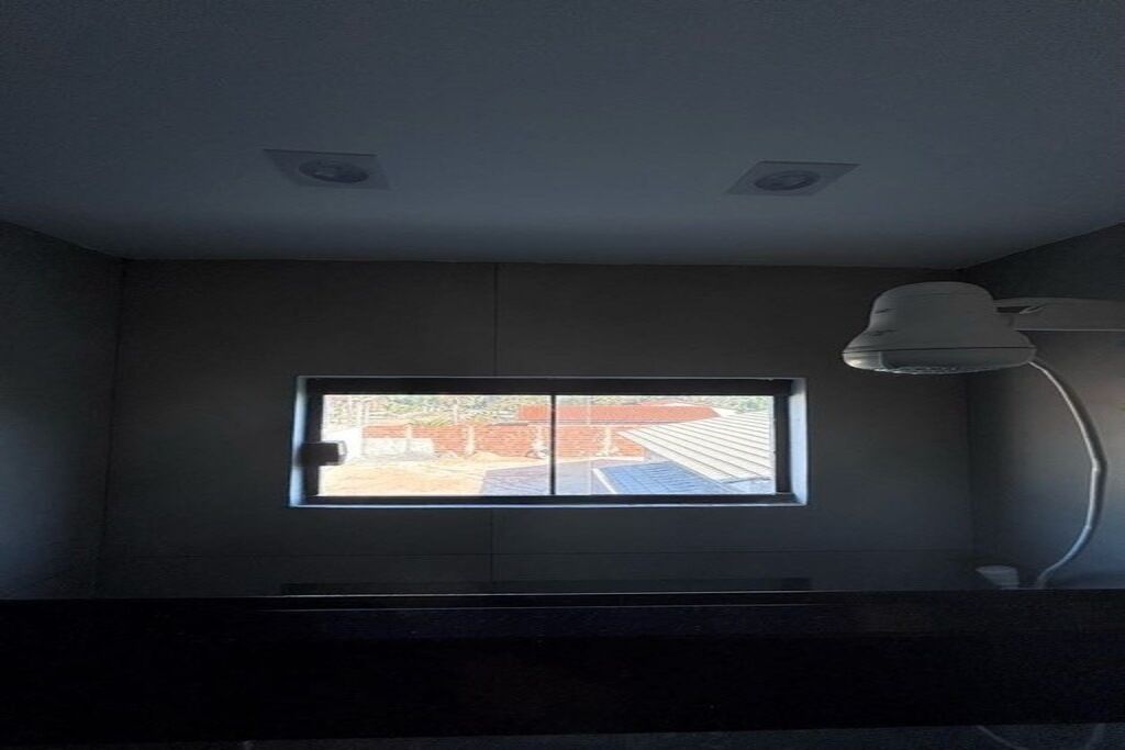 A room with a window, a desk, and a lamp.