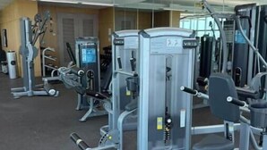 A gym with various exercise machines, including a leg press and a chest press. - Dream Stay (Fort Myers)