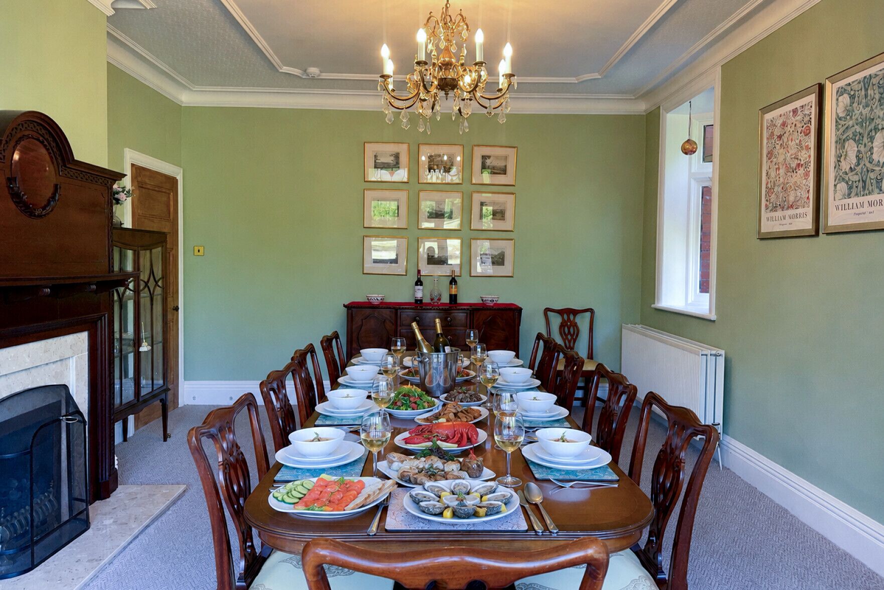 A dining room with a long table set for a meal, surrounded by chairs.