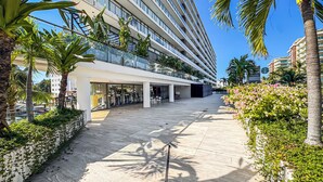 A modern hotel with a central courtyard, outdoor seating, and a Starbucks sign. - Luxury Corner Condo at Nima Bay | Marina Vallarta (Puerto Vallarta)