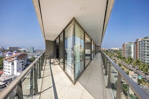 A balcony with a view of the cityscape, including buildings and a marina. - Luxury Corner Condo at Nima Bay | Marina Vallarta (Puerto Vallarta)