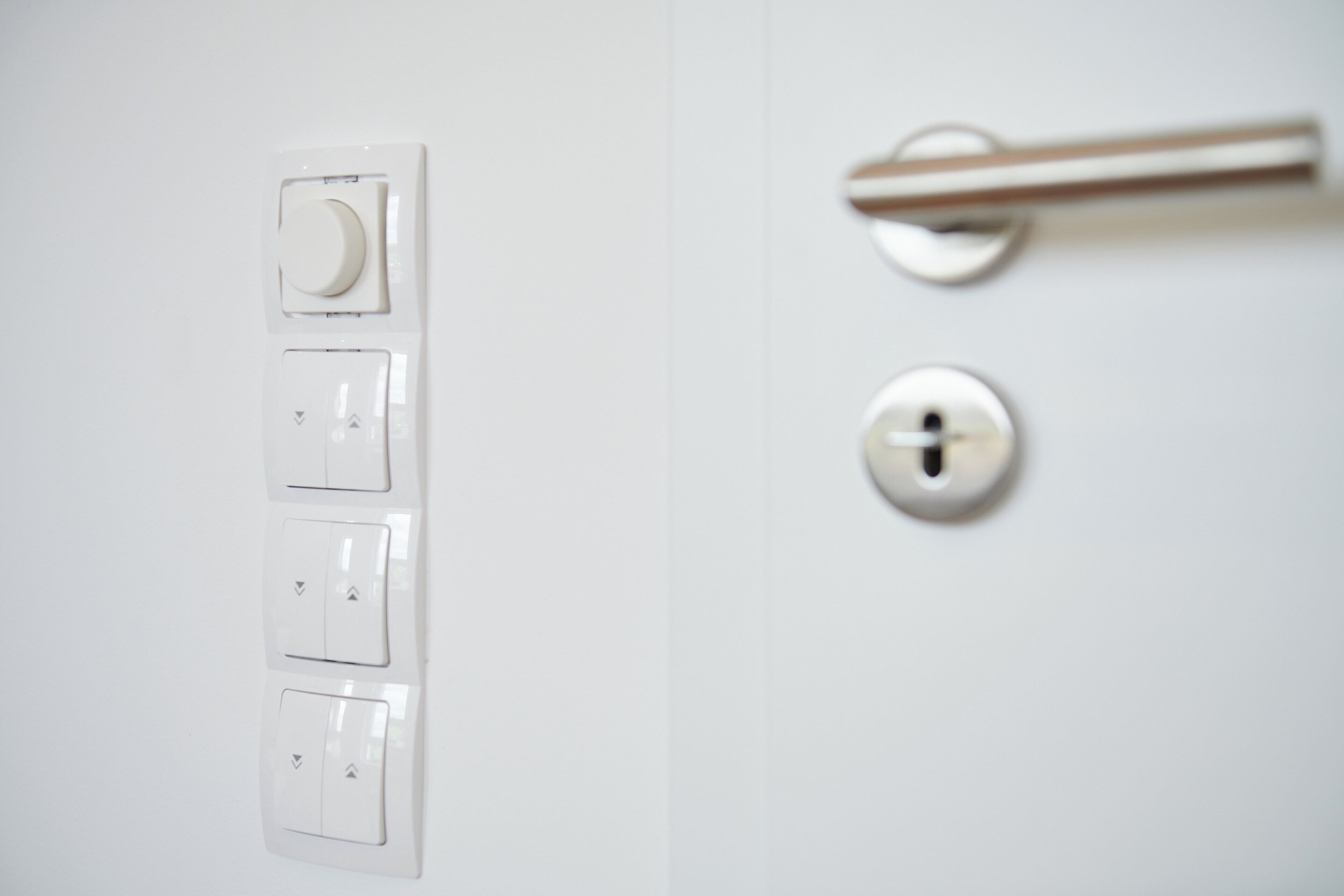 A white door with a silver handle and a keyhole.
