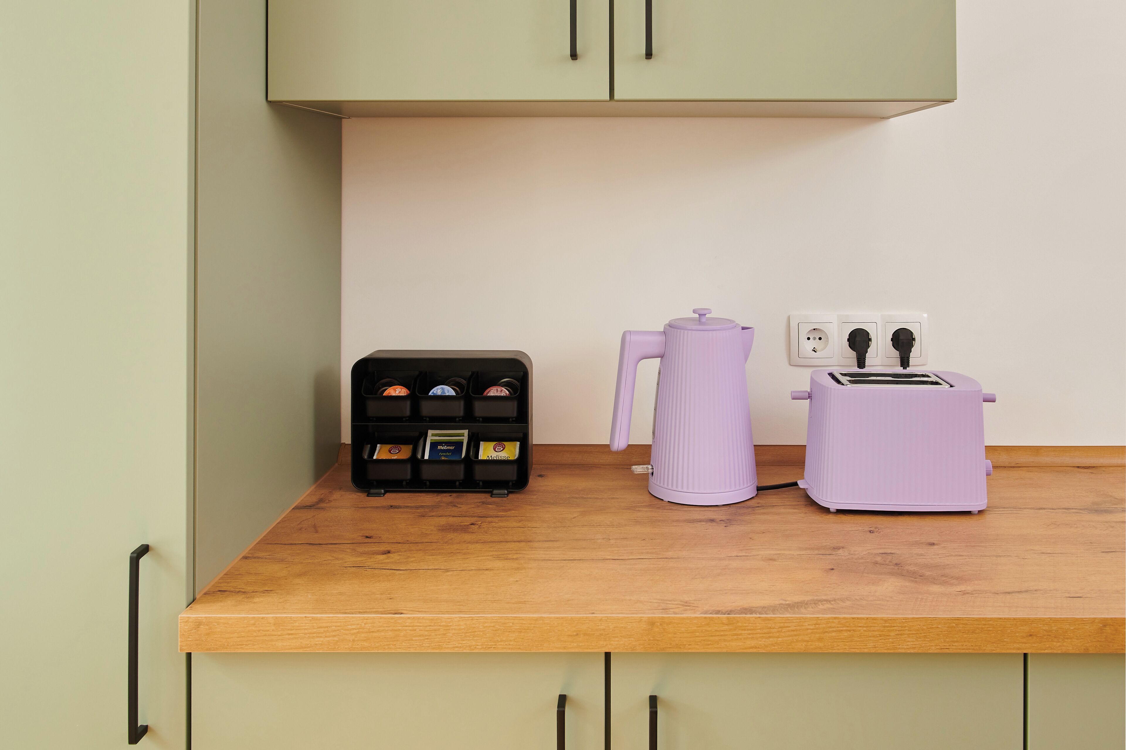 Eine Küchenzeile mit Kaffeemaschine, Toaster und Gewürzregal.