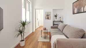 A modern living room with a sofa, a coffee table, and a potted plant. - HomeME Bad Oeynhausen City (Bad Oeynhausen)