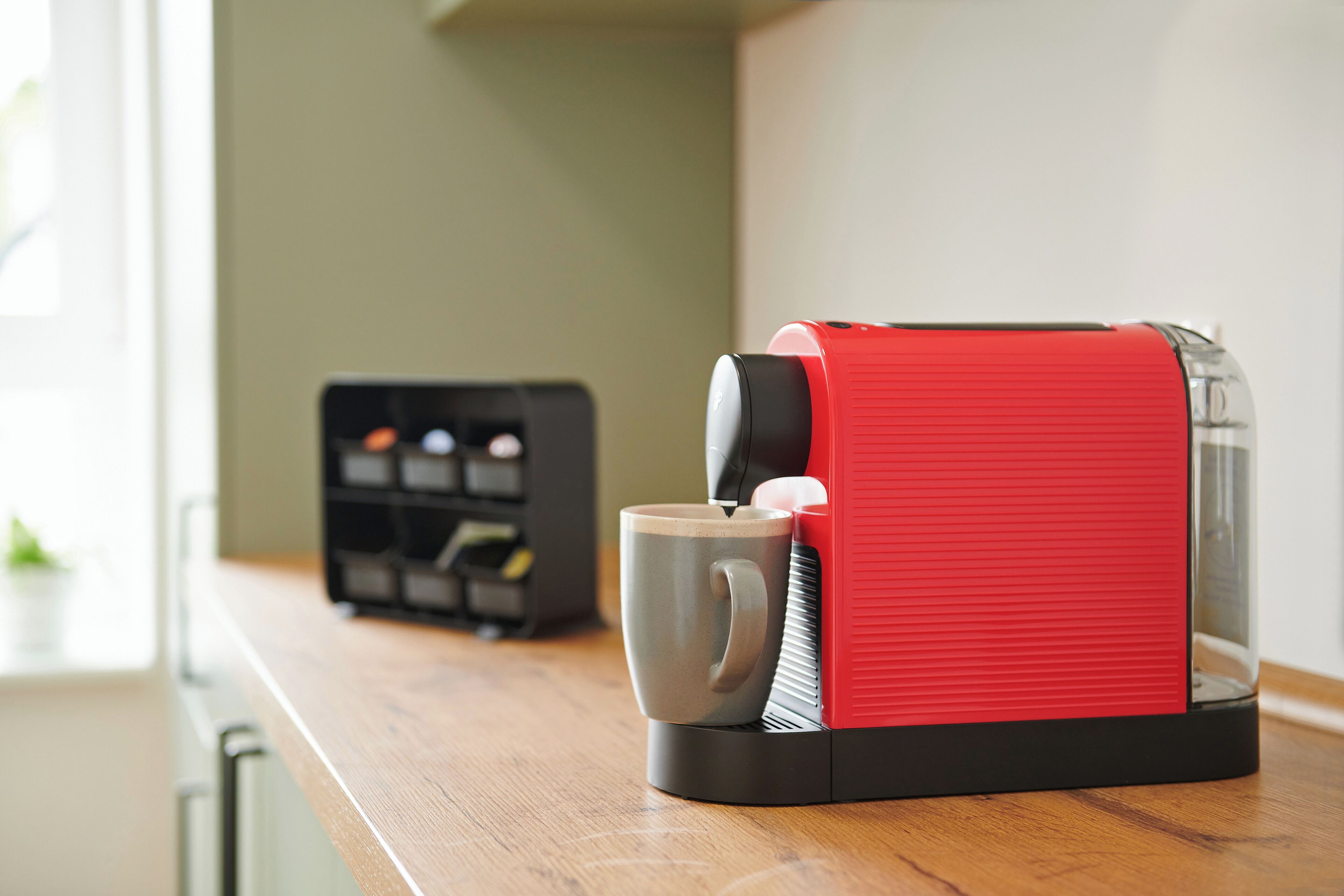 A coffee maker with a red and black design on a kitchen counter.