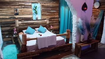 A rustic wooden room with a bed, a small table, and a wall clock.