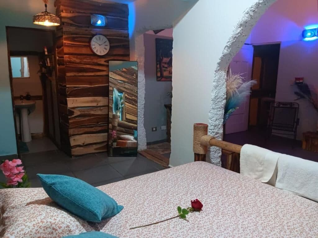 Een slaapkamer met een bed, een klok en een houten wand.