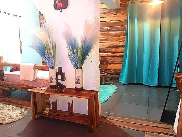 A room with a wooden bench, decorative vases, and a stone wall.