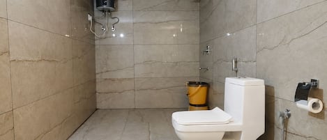 Un baño con inodoro, ducha y perchero.