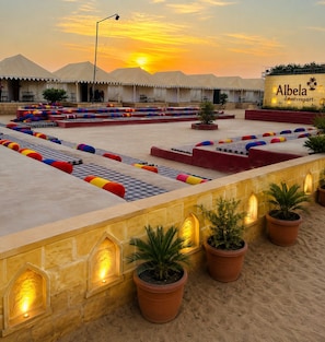 A desert resort with tents, colorful seating, and potted plants. - Albela Desert Resort  (Sam)
