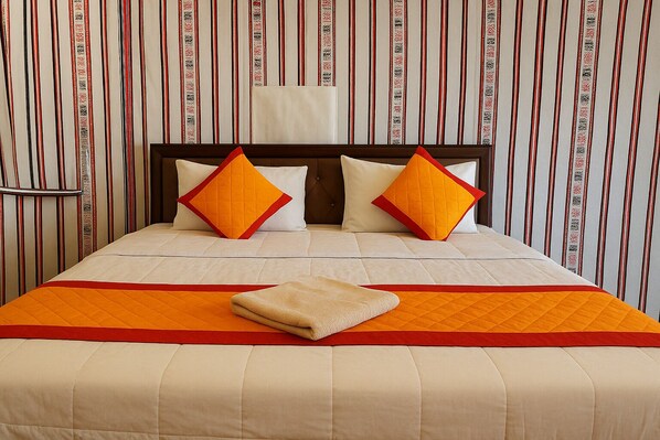 A hotel room with a bed, two pillows, a blanket, and a headboard. - Albela Desert Resort (Sam)