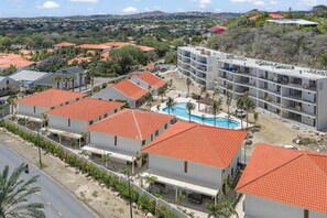 A resort with multiple buildings, a swimming pool, and a hilly landscape in the background. - Brisazou - Appartment 2 with 2 bedrooms (Willemstad)