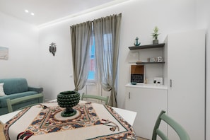 Un saló modern amb una taula de dinar, un sofà i un moble amb objectes decoratius.