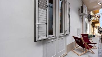 Un edificio con facciata bianca, una porta con maniglia e una finestra con persiane.