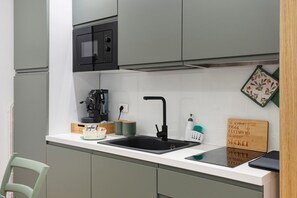 Cafetera o tetera, frigorífico, microondas y placa de cocina