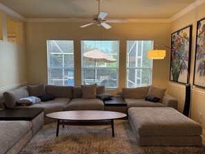 A living room with a sofa set, a coffee table, and a ceiling fan. - Minutes to the Sand! Pets! Charming 3-bedroom in beautiful Bradenton. (Bradenton)