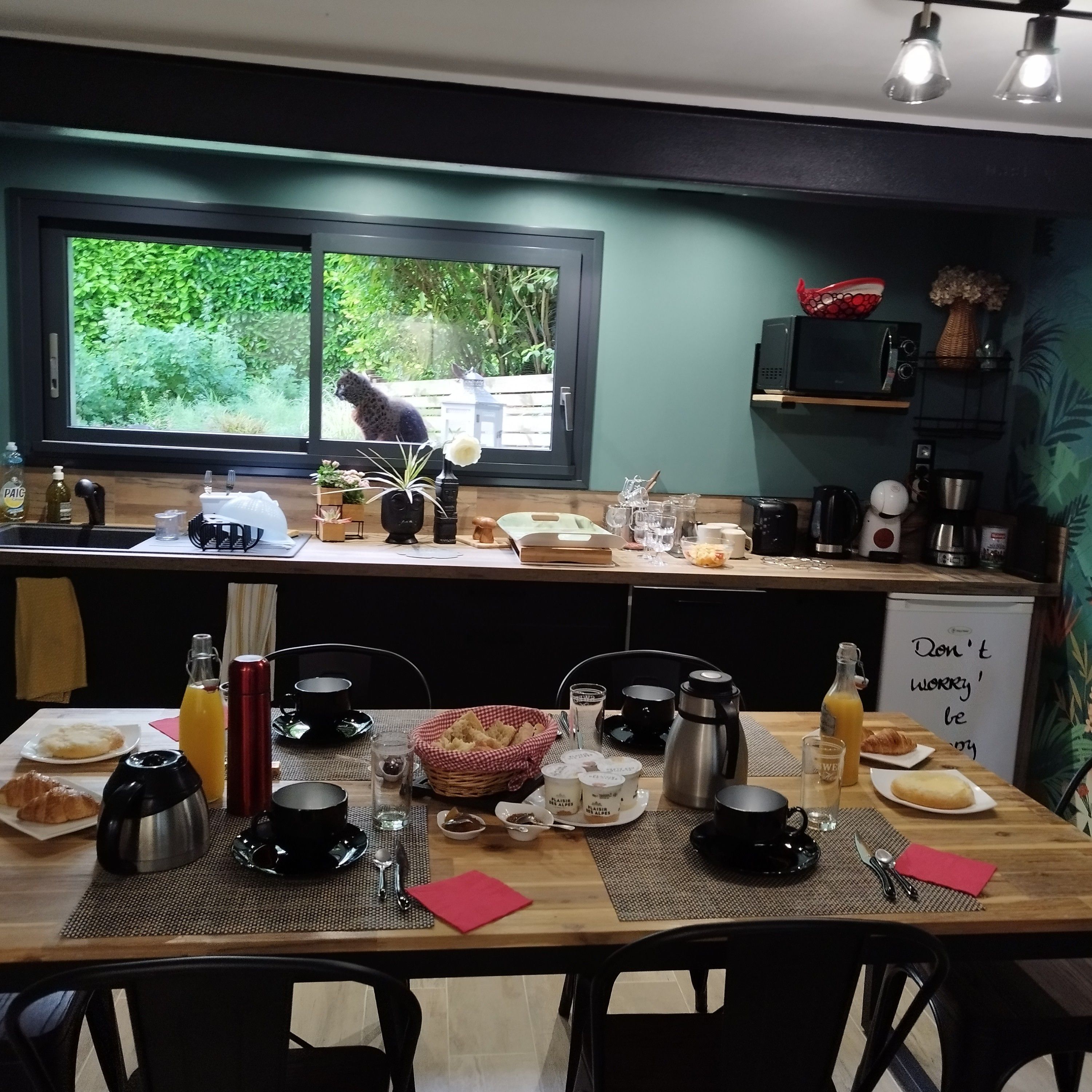 A breakfast setting with a table set for two, including croissants, coffee, and juice.