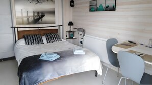 A bedroom with a bed, bedside table, lamp, and a desk with a chair. - Bed and Breakfast 'Chambre Paladru' with Mountain View, Shared Pool and Wi-Fi (Charancieu)