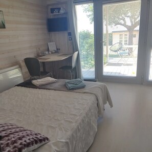 A hotel room with a bed, a desk, and a view of the outside. - Bed and Breakfast 'Chambre Paladru' with Mountain View, Shared Pool and Wi-Fi (Charancieu)
