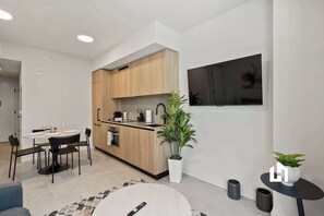 A modern kitchen with wooden cabinets, a built-in oven, and a black countertop. - Modern Balcony Condo Near Kaseya and Museums (Miami)