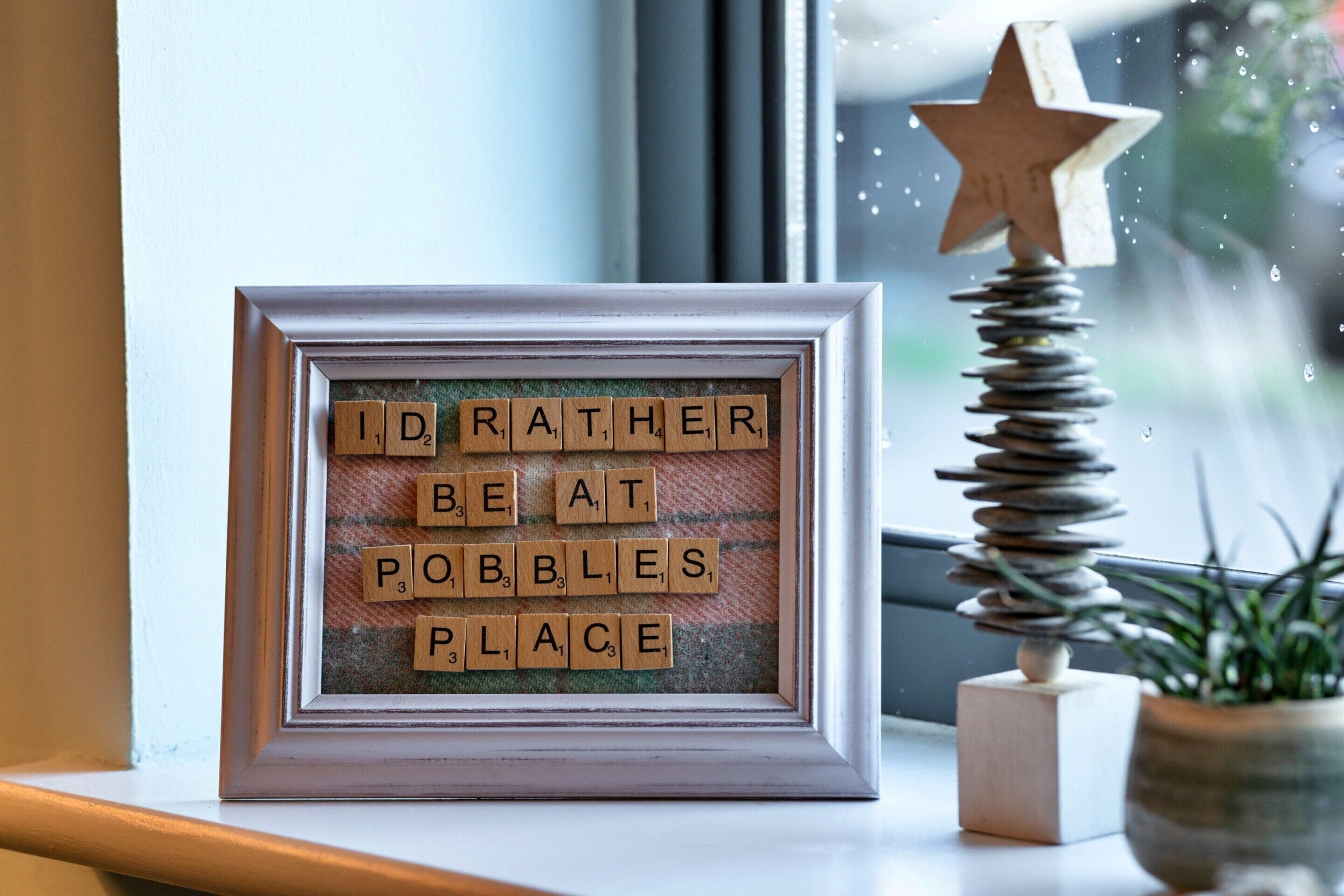 A framed message board with the text 'I rather beat at pibbles place' and a wooden star decoration.