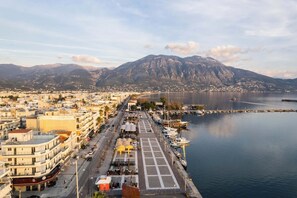 A coastal cityscape with a marina, buildings, and mountains in the background. - Socrates Suite C3 - Open City Views in Kalamata (Kalamata)