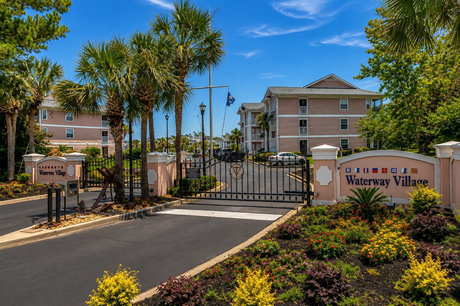 A gated entrance to a residential complex with a sign reading 'Waterway Village.'