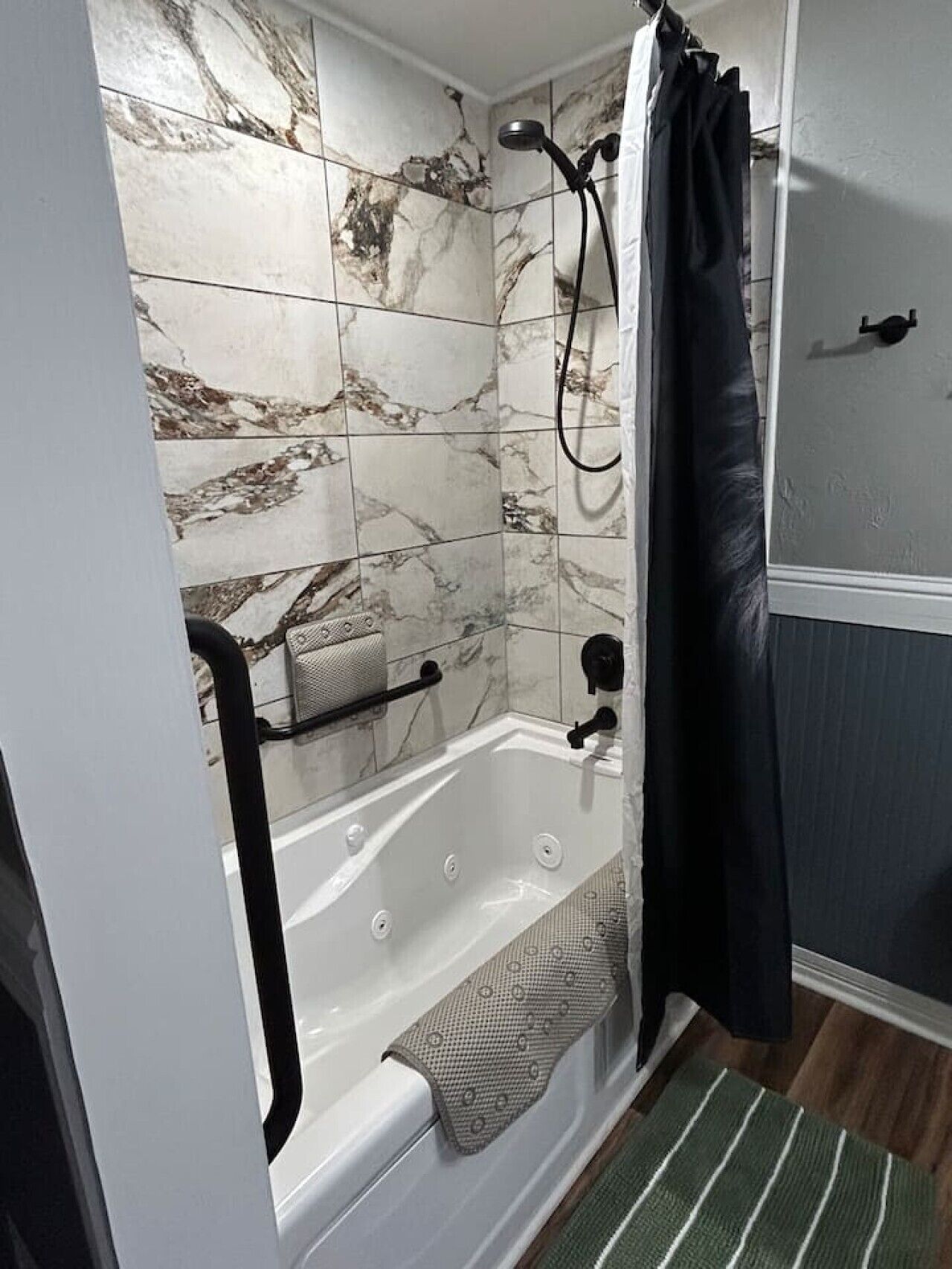 A bathroom with a bathtub, shower, and tiled walls.