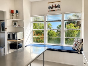 A kitchen with a built-in bench, a microwave, and a toaster oven. - Copano Bay Waterfront Cottage with 300 Ft Fishing Pier, sleeps 8, Pets Ok (Bayside)