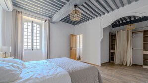 Un dormitorio con una cama grande, un armario y un espejo.
