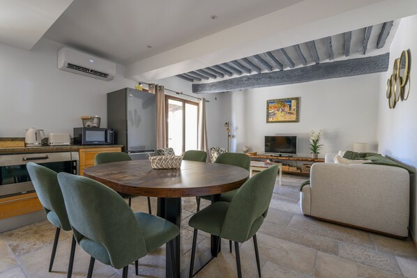 A modern living space with a dining area, kitchen, and seating area.