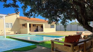 A residential property with a swimming pool, a wooden bench, and a house with a tiled roof. - Villa Emilia  (Oranjestad)