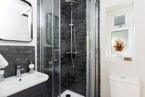 A modern bathroom with a glass-enclosed shower, a white sink, and a toilet. - South Wales Lodge With Patio (Newport)